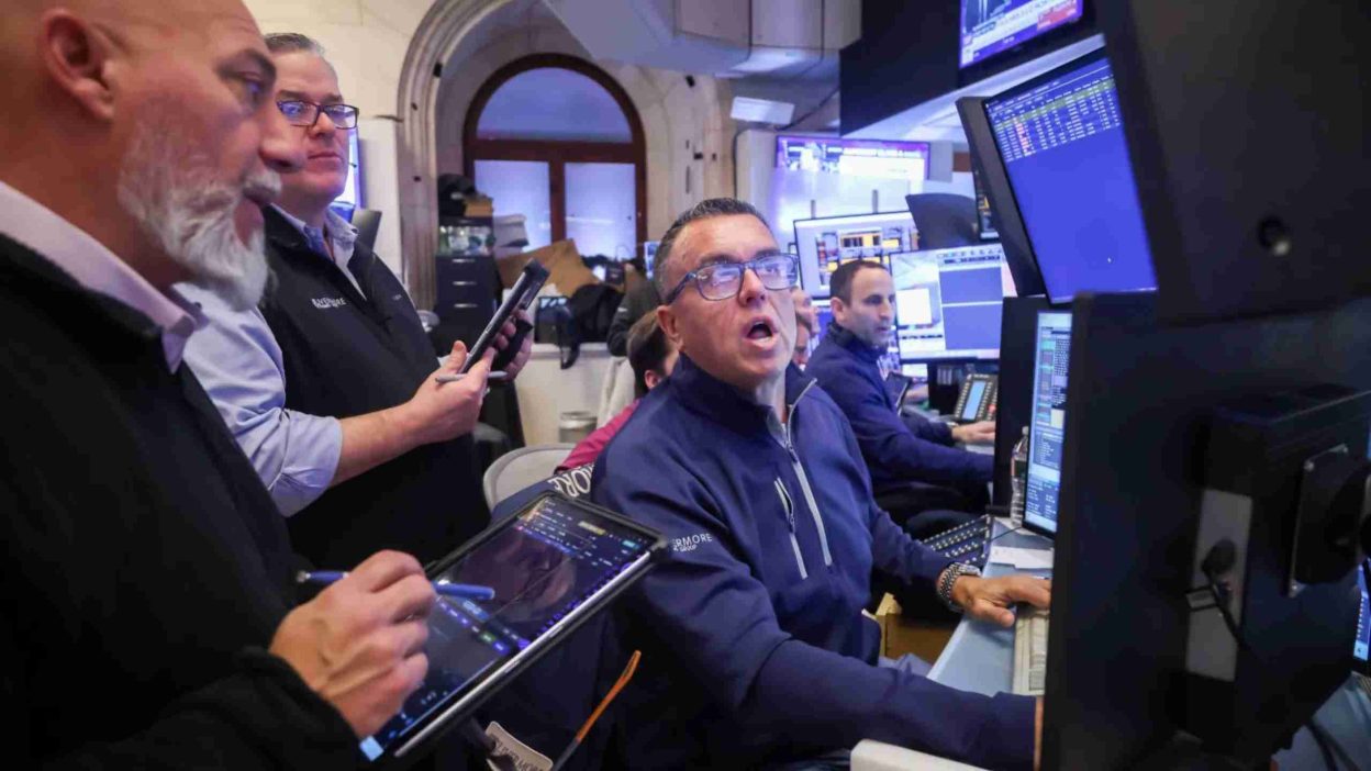Traders watching market screens as U.S. stock futures advance ahead of key data