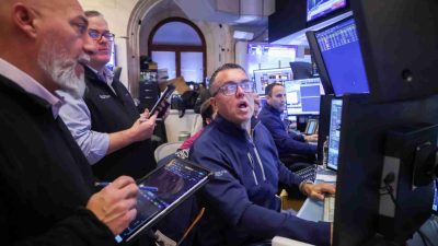 Traders watching market screens as U.S. stock futures advance ahead of key data